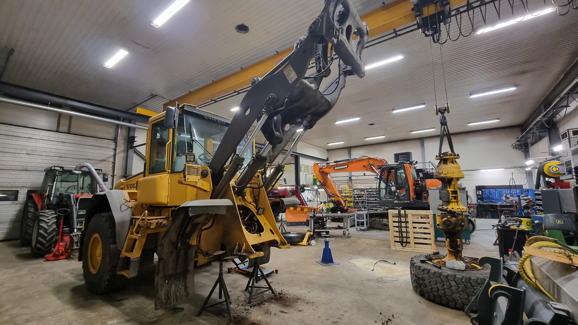 Volvo-pyöräkuormaaja ja Doosan-kaivinkone huollossa suomalaisessa raskaan kaluston korjaamossa